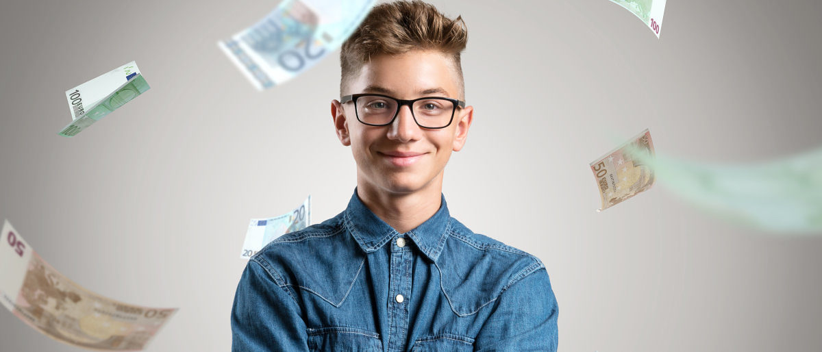 Das Weiterbildungsstipendium unterstützt begabte junge Handwerker. Porträt eines jungen Mannes mit Brille und in Jeanshemd vor einem grauen Hintergrund. Um ihn herum regnet es Euroscheine.