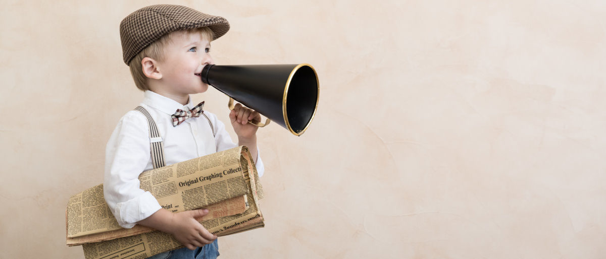 Neue Broschüre mit Tipps zur Pressearbeit für kleine Handwerksbetriebe Kleiner Junge in altmodischer Kleidung hält eine Zeitung unter dem rechen Arm und ein Megafon in der linken Hand vor dem Mund